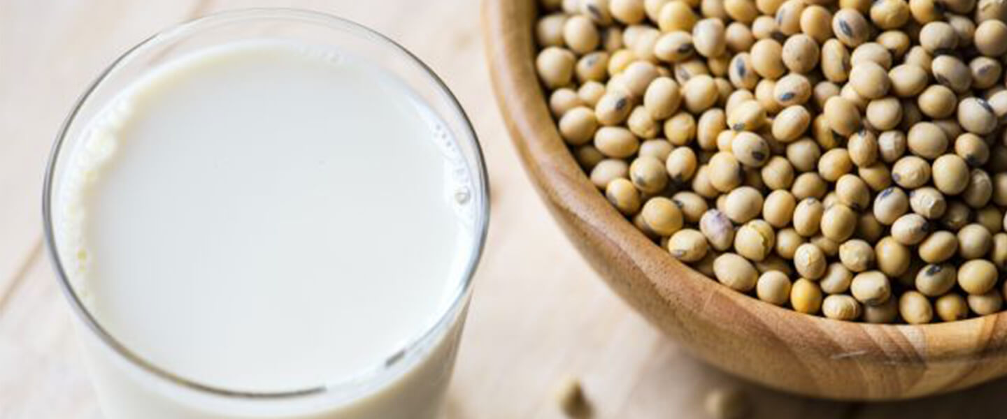 Glass of milk next to a bowl of Soybeans